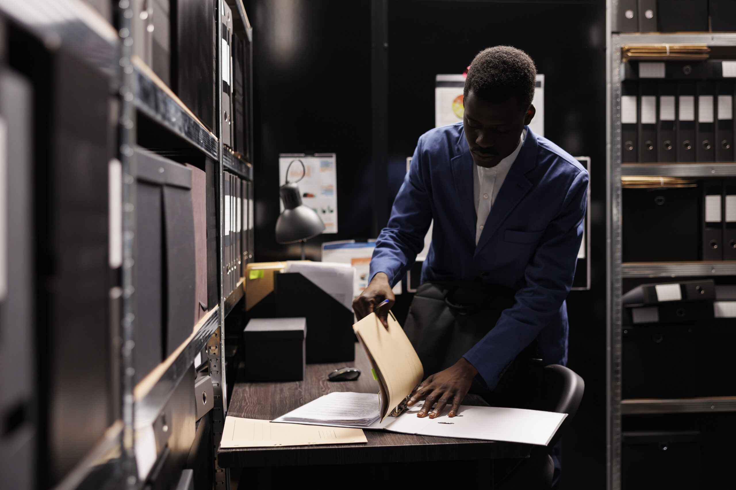 african american manager gathering his stuff preparing leave job late night after working accountancy report file room employee searching bureaucracy record corporate depository scaled