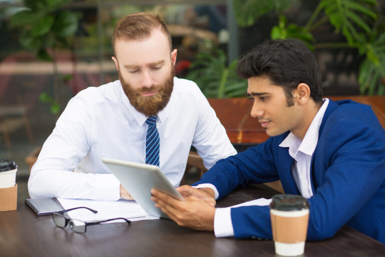 pensive colleagues using modern device while taking statistics